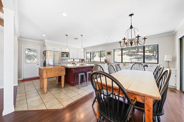 dining area featuring crown molding, plenty of natural light, light hardwood / wood-style floors, and a notable chandelier