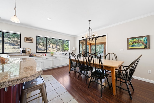 dining room with hardwood / wood-style floors, crown molding, and an inviting chandelier