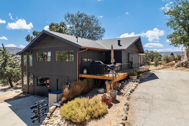 view of front facade featuring a deck with mountain view and a patio area