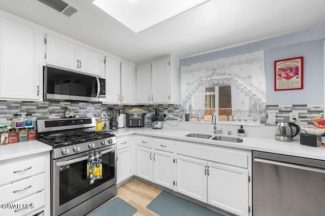 43656 E 5th St, Lancaster, CA 93535 - kitchen with appliances with stainless steel finishes, white cabinets, light countertops, and decorative backsplash