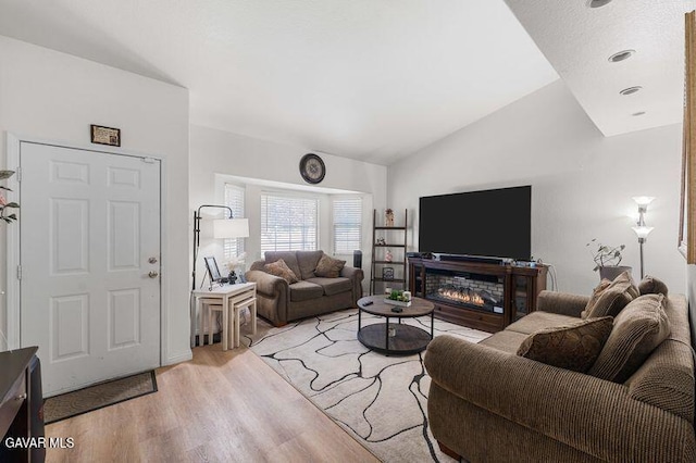 43656 E 5th St, Lancaster, CA 93535 - living room with light wood-style floors, vaulted ceiling, and a glass covered fireplace