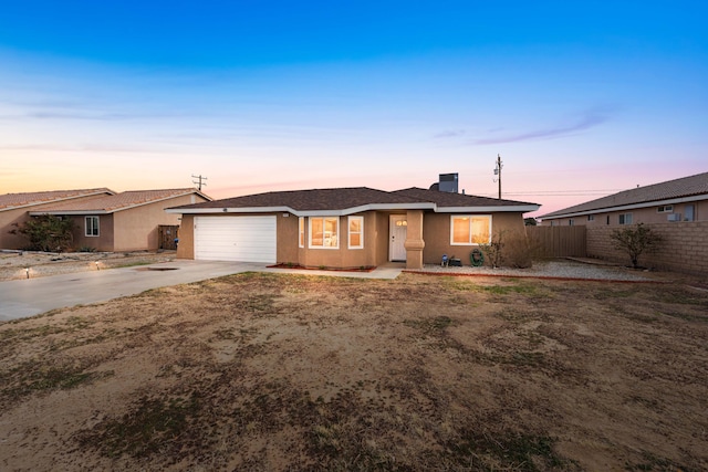 ranch-style home featuring driveway, a garage, fence, and stucco siding