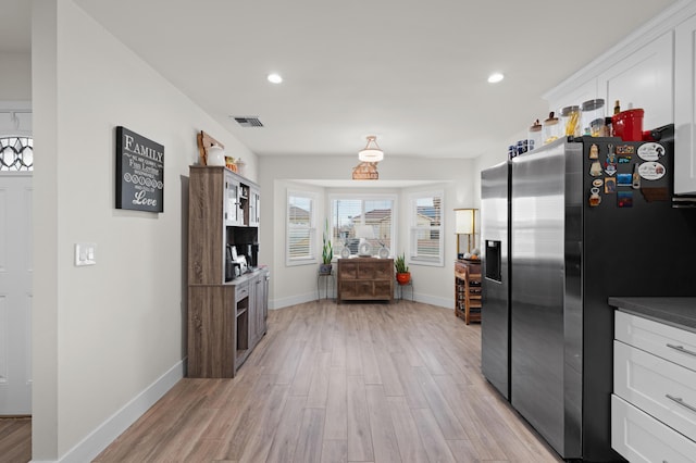 kitchen featuring recessed lighting, white cabinets, light wood finished floors, and stainless steel fridge with ice dispenser