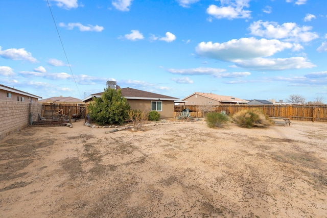 back of property with a fenced backyard and stucco siding