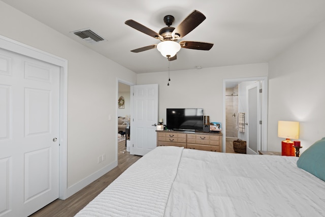 bedroom featuring ceiling fan, connected bathroom, dark wood-style flooring, visible vents, and baseboards