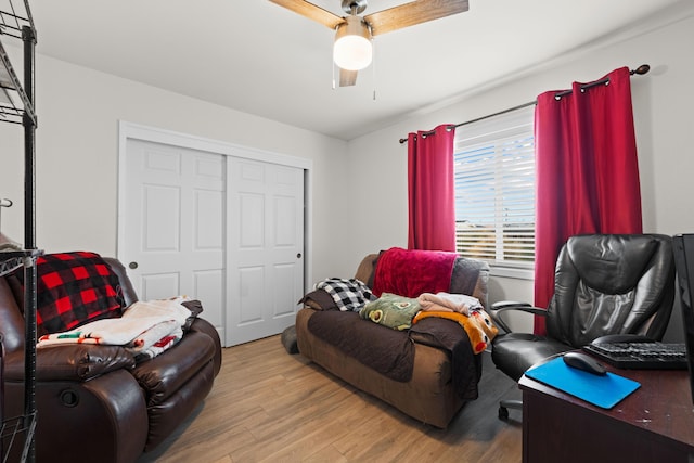 living area with wood finished floors and a ceiling fan