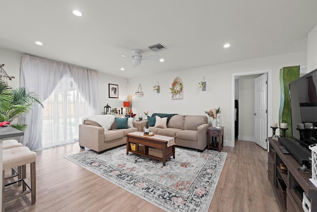 living area with light wood-type flooring, visible vents, and recessed lighting