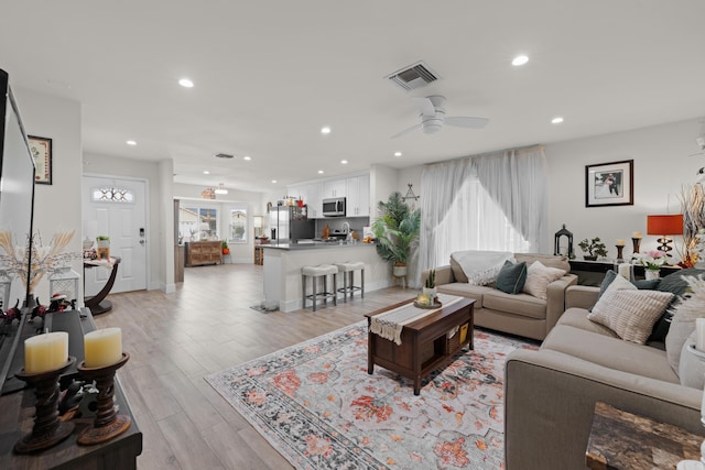 living room featuring recessed lighting, visible vents, ceiling fan, and light wood-style flooring