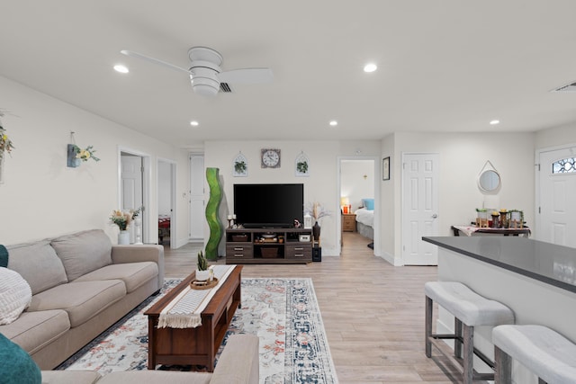 living area with light wood finished floors, ceiling fan, and recessed lighting