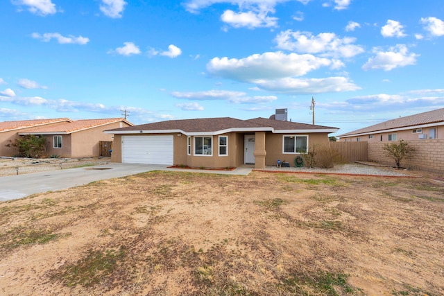 ranch-style home featuring a garage, concrete driveway, fence, and stucco siding