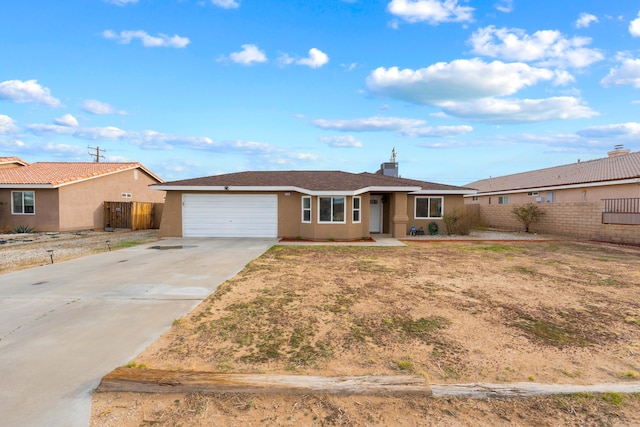 ranch-style house featuring a garage, fence, driveway, and stucco siding