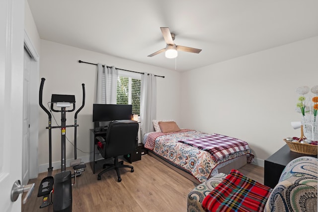 bedroom featuring ceiling fan, a closet, baseboards, and wood finished floors