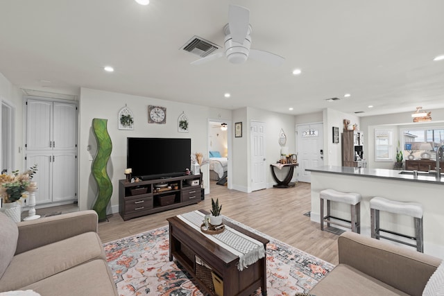 living room with recessed lighting, visible vents, baseboards, a ceiling fan, and light wood finished floors