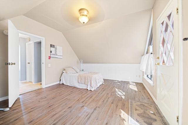 unfurnished bedroom featuring ceiling fan, light hardwood / wood-style floors, and lofted ceiling