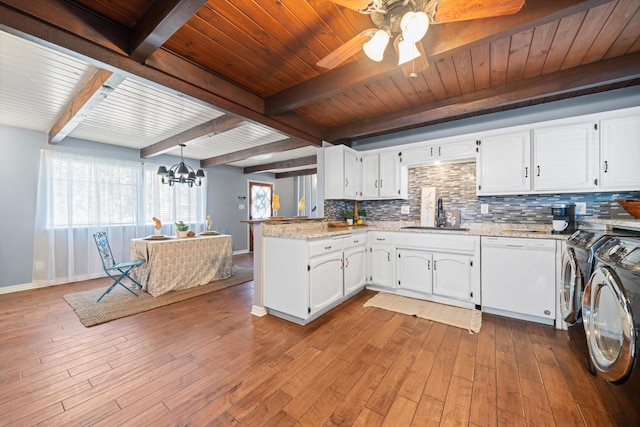 kitchen with sink, separate washer and dryer, light stone counters, white dishwasher, and white cabinets