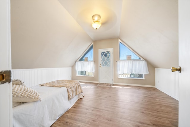 bedroom with hardwood / wood-style floors and lofted ceiling