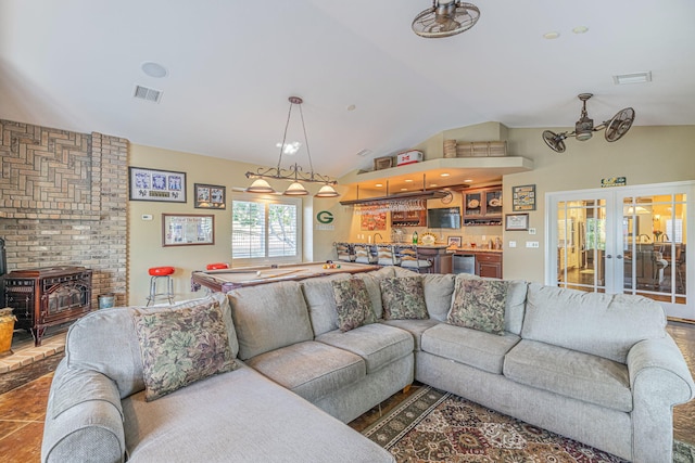 living room with a wood stove, french doors, and lofted ceiling