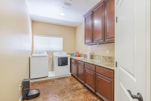 washroom with washer and dryer, cabinets, and sink