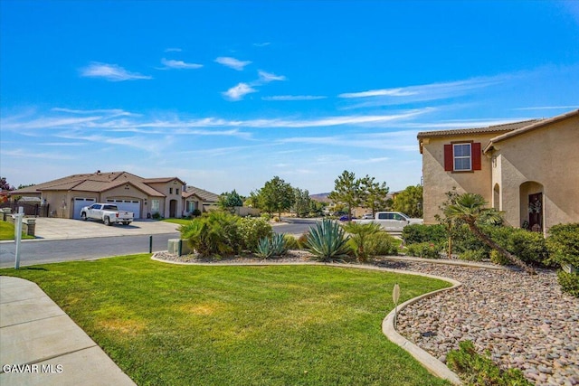 41729 Firenze St, Lancaster, CA 93536 - view of grassy yard featuring a garage, driveway, and a residential view