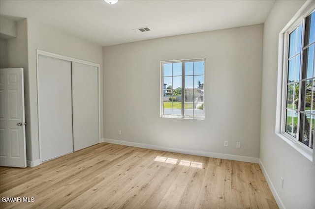 41729 Firenze St, Lancaster, CA 93536 - unfurnished bedroom with multiple windows, light wood-type flooring, and a closet
