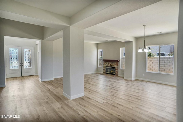 41729 Firenze St, Lancaster, CA 93536 - unfurnished living room with light wood-style flooring, plenty of natural light, a chandelier, and a fireplace