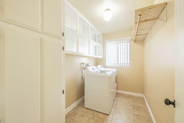 laundry area with baseboards and washer and clothes dryer