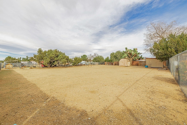 view of yard with an outbuilding, a fenced backyard, and a storage unit