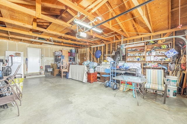 garage featuring freestanding refrigerator and a garage door opener