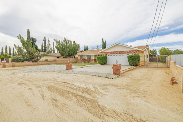 view of front of property with an attached garage, a gate, fence, and driveway