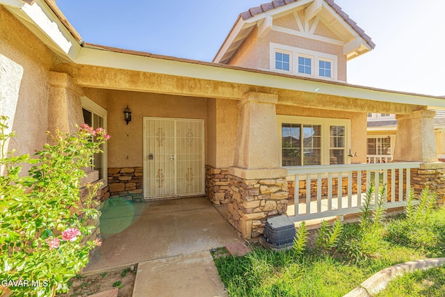 4068 Vancouver Ln, Quartz Hill, CA 93536 - doorway to property featuring stone siding, covered porch, and stucco siding