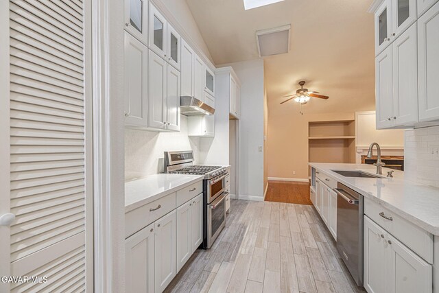 4068 Vancouver Ln, Quartz Hill, CA 93536 - kitchen with stainless steel appliances, under cabinet range hood, white cabinetry, light wood-style flooring, and a ceiling fan