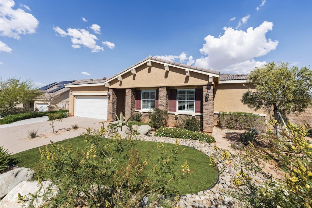 41840 Sonoma Rd, Palmdale, CA 93551 - view of front facade featuring stucco siding, concrete driveway, an attached garage, stone siding, and a tile roof