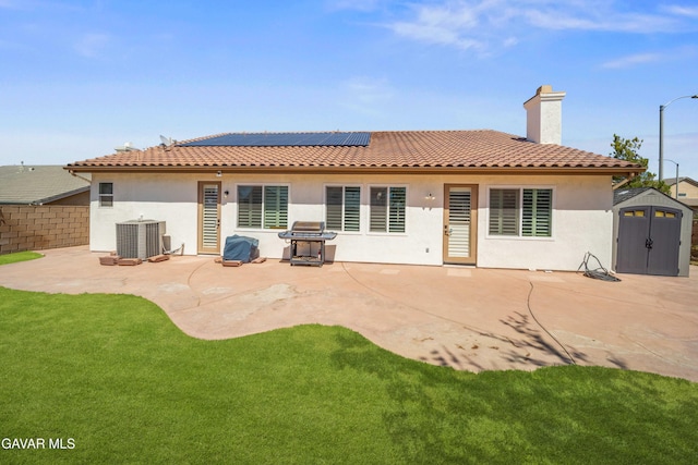 42409 W 66th St, Lancaster, CA 93536 - rear view of property featuring a storage unit, stucco siding, roof mounted solar panels, and a patio area
