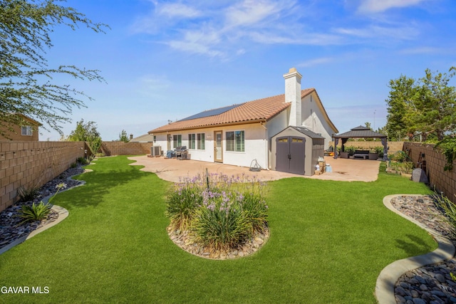 42409 W 66th St, Lancaster, CA 93536 - rear view of house with a gazebo, a patio, roof mounted solar panels, a chimney, and a tiled roof