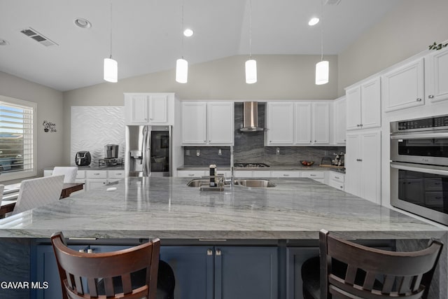 42409 W 66th St, Lancaster, CA 93536 - kitchen with appliances with stainless steel finishes, wall chimney range hood, vaulted ceiling, decorative backsplash, and white cabinets