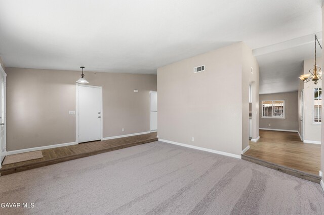 4633 Dowel Ave, Palmdale, CA 93552 - unfurnished room with carpet floors, a chandelier, and wood finished floors