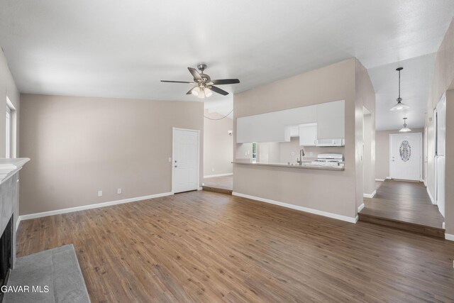 4633 Dowel Ave, Palmdale, CA 93552 - unfurnished living room with a ceiling fan, wood finished floors, a tile fireplace, and vaulted ceiling
