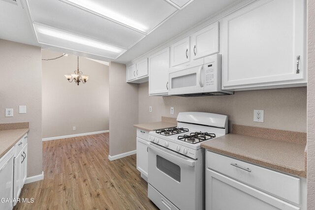 4633 Dowel Ave, Palmdale, CA 93552 - kitchen with white appliances, a chandelier, light wood finished floors, and white cabinets