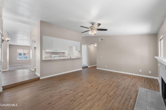 4633 Dowel Ave, Palmdale, CA 93552 - unfurnished living room featuring a ceiling fan, wood finished floors, and a tiled fireplace