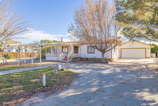 ranch-style home with covered porch, an outdoor structure, and a garage