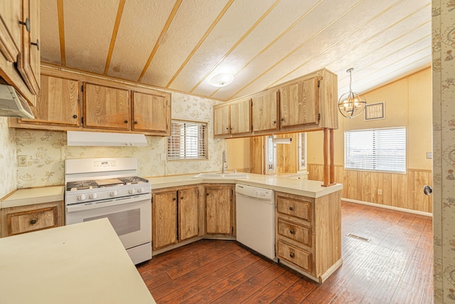 kitchen with sink, hanging light fixtures, kitchen peninsula, vaulted ceiling, and white appliances