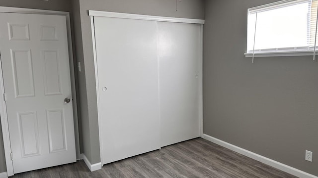 unfurnished bedroom with a closet and hardwood / wood-style flooring