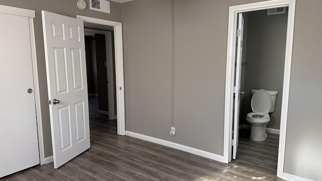 unfurnished bedroom with dark hardwood / wood-style floors and ensuite bath