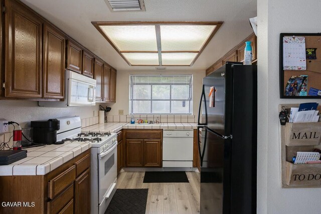 425 W W Ave J5, Unit 37, Lancaster, CA 93534 - kitchen featuring white appliances, light wood-style flooring, and tile counters
