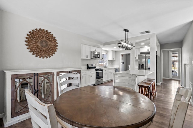 dining area featuring dark hardwood / wood-style flooring and a chandelier