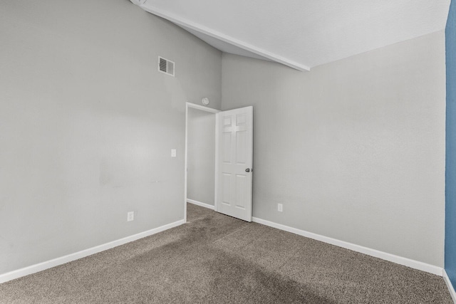 carpeted empty room with vaulted ceiling