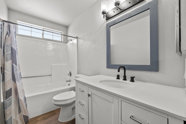 full bathroom with shower / tub combo with curtain, vanity, wood-type flooring, a textured ceiling, and toilet