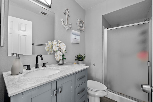 bathroom with vanity, an enclosed shower, and toilet