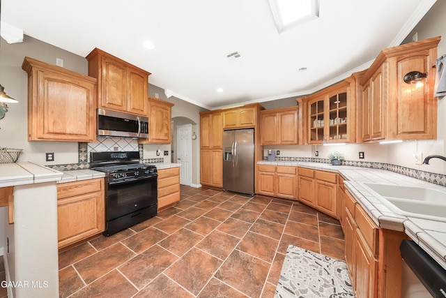 33430 E 133rd St, Pearblossom, CA 93553 - kitchen with appliances with stainless steel finishes, glass insert cabinets, ornamental molding, arched walkways, and tile countertops