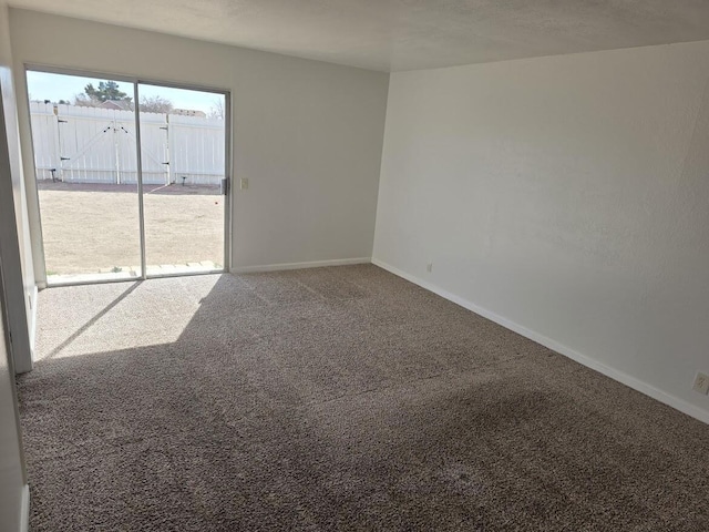 carpeted spare room featuring baseboards